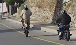 Akrobasi hareketleri yaparak motosiklet kullanan şahıs kamerada