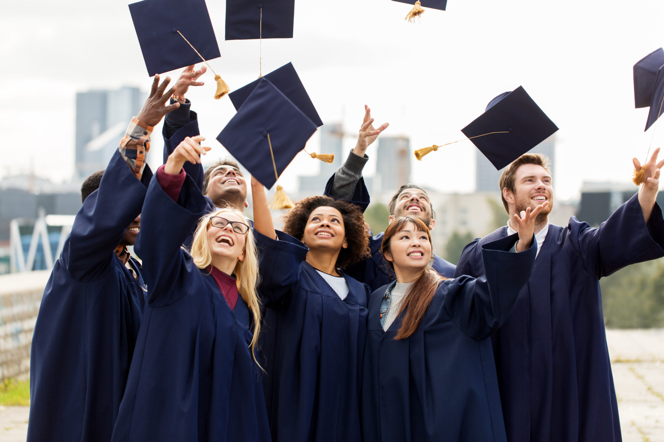 Happy Graduates Students Throwing Mortar Boards Scaled